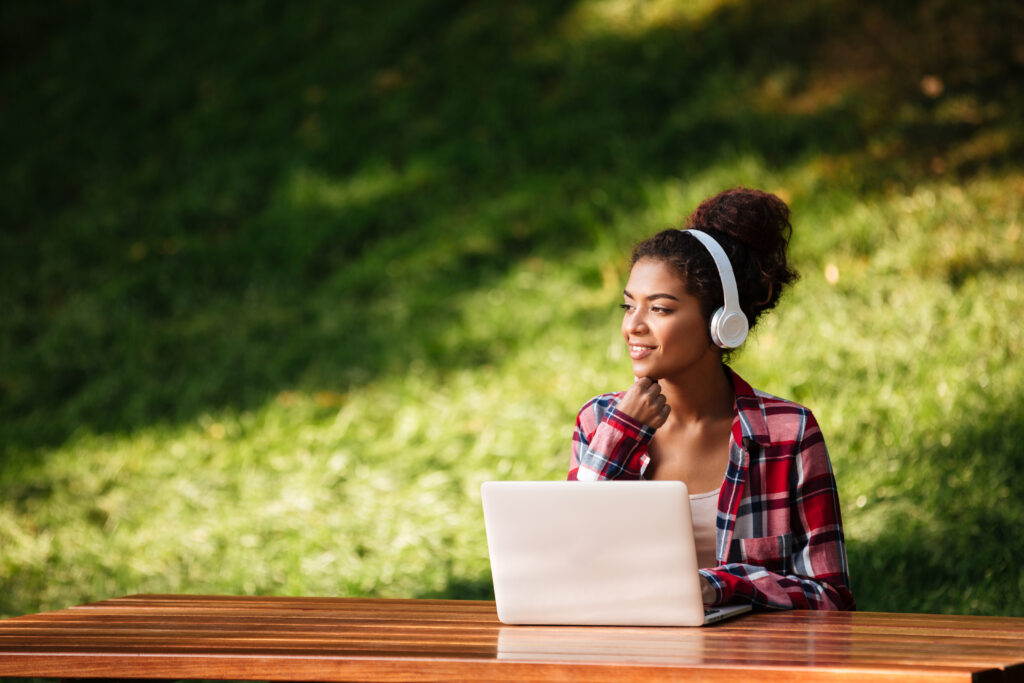 African woman sitting outdoors in park. Validation des Acquis de l’Expérience (VAE) – Obtenez une certification grâce à votre expérience professionnelle