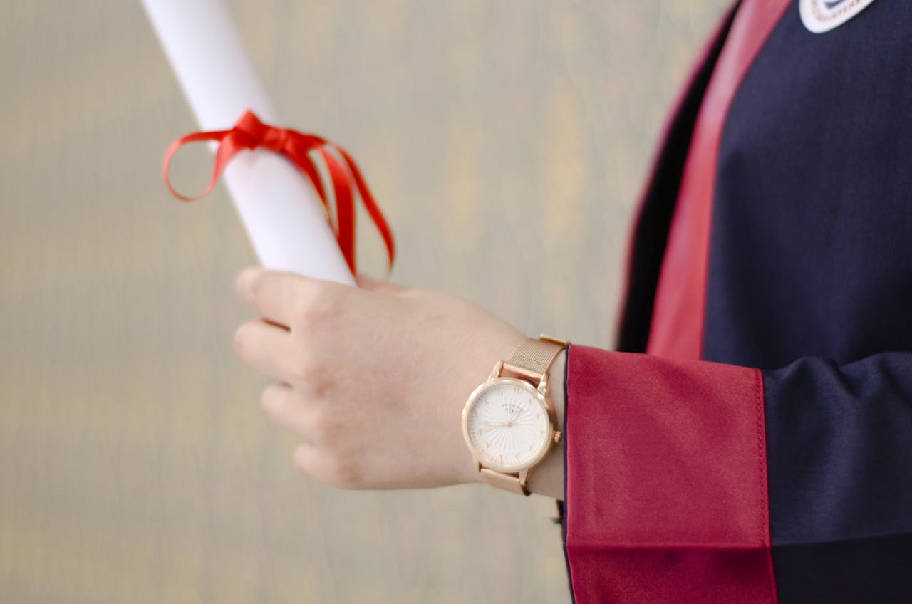 A close-up of a graduates hand holding a diploma, symbolizing success and achievement.